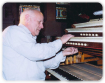 Sideview of Man Playing Pipe Organ