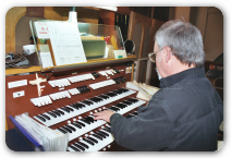 Sideview of Man Playing Pipe Organ